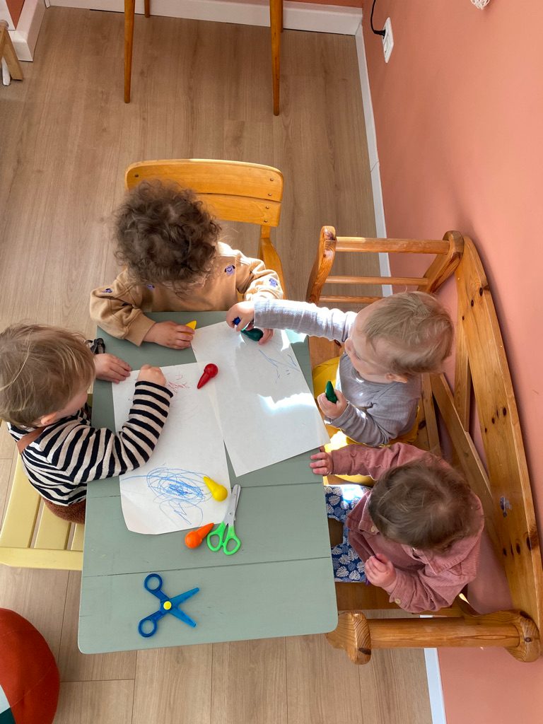 Vier Kinder basteln und malen gemeinsam am Tisch