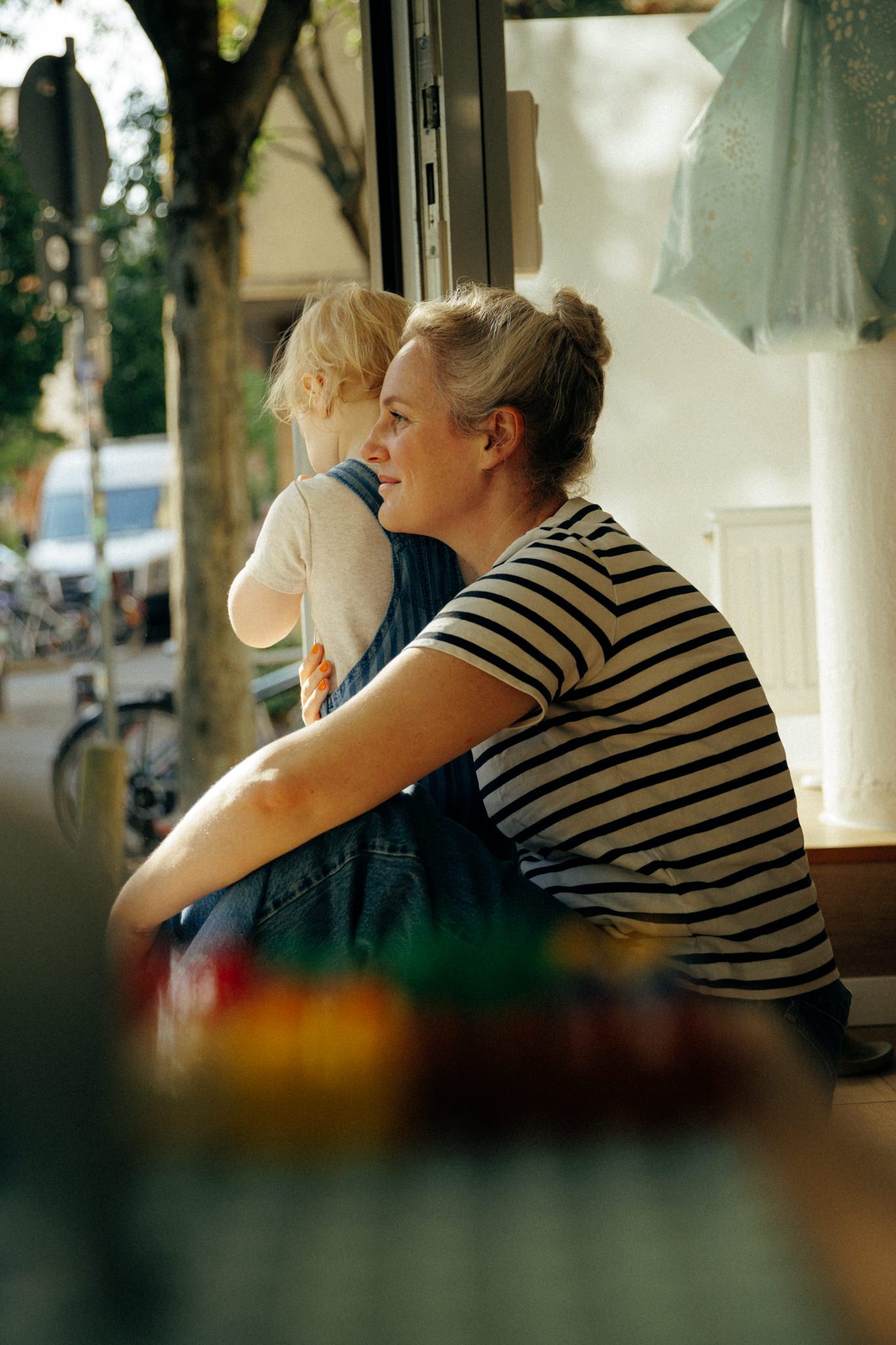 Tita und Kind sitzen im Eingang, Blick zur Straße