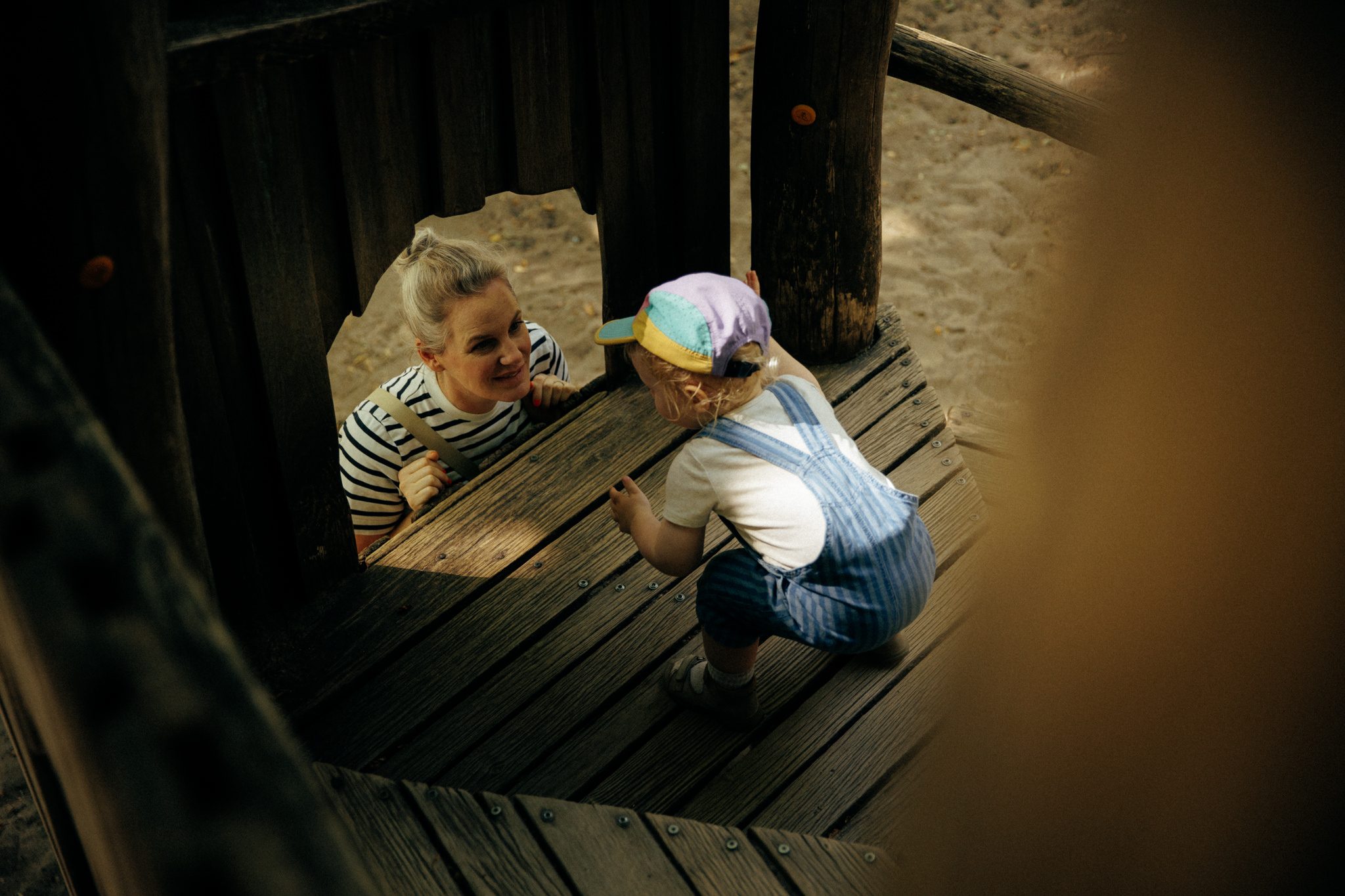 Kind klettert am Klettergerüst, Tita schaut zu