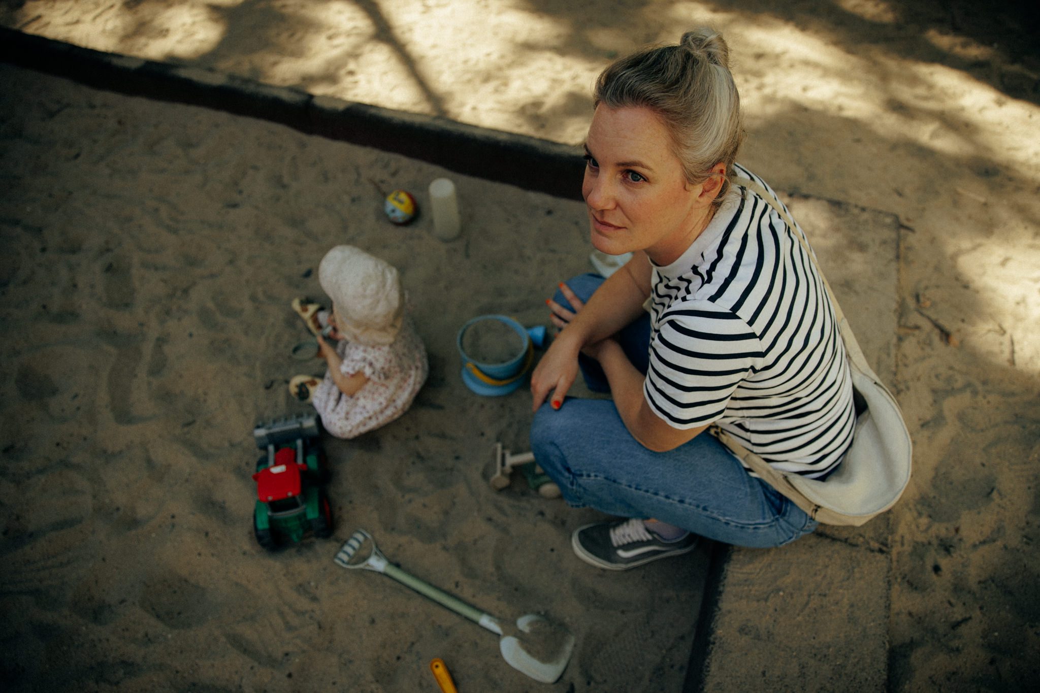 Tita und Kinder spielen im Sandkasten auf dem Spielplatz